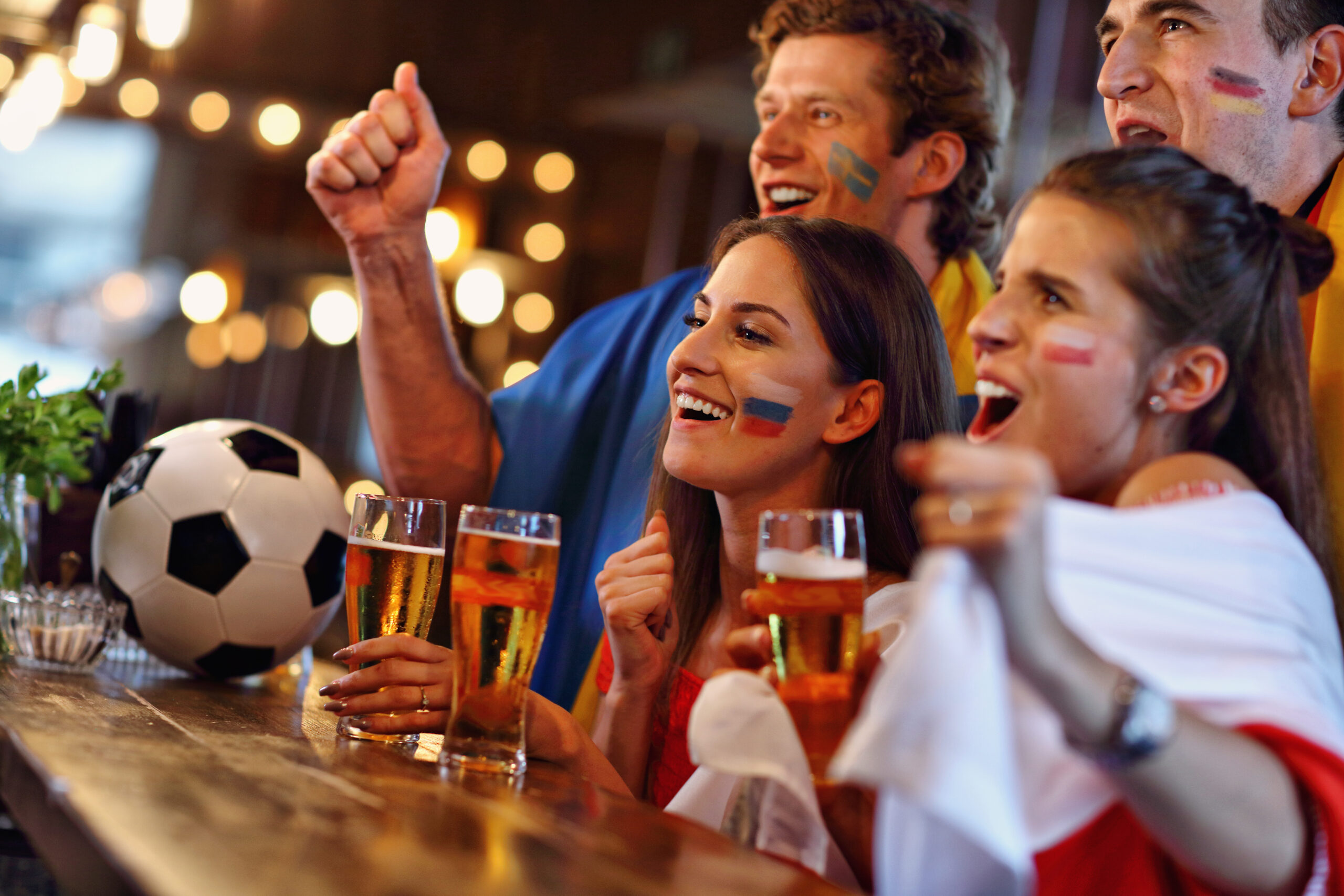Group of friends watching soccer game in pub