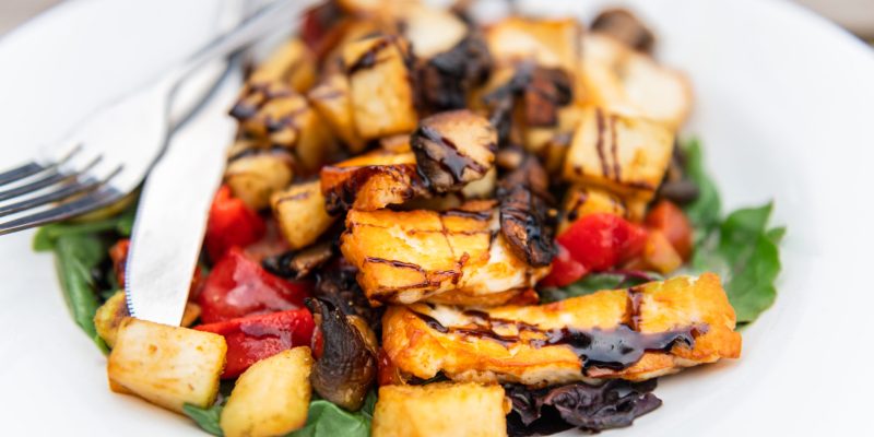 Grilled halloumi cheese with fried vegetables and mushrooms , served in English pub as warm salad