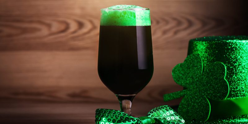 Saint Patrick's Day green beer closeup against wooden background. Traditional Saint Patrick's Day drink in a glass, holiday concept